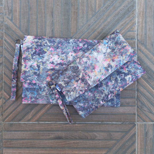 Small and large size printed clutch bags on a patio floor