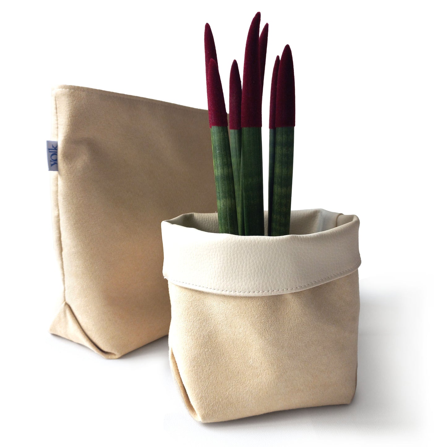Two sand yellow storage baskets, one used as a plant pot
