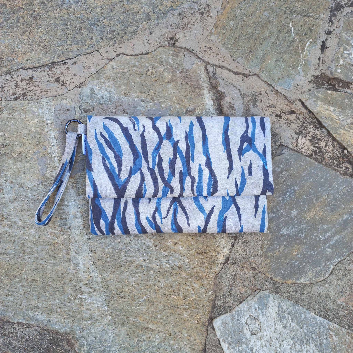 Vegan suede clutch bag on a stone floor
