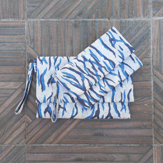 Small and large printed fabric clutches on a patio floor