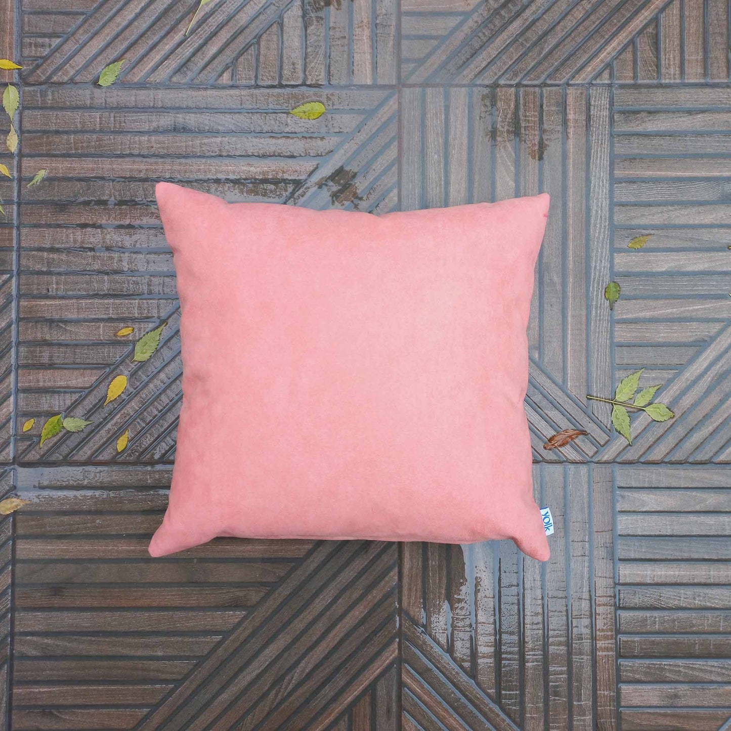 Pink decorative cushion on rainy balcony floor