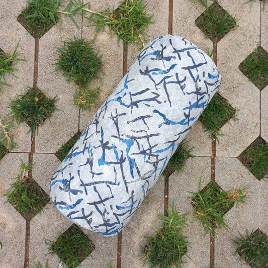 Printed decorative bolster cushion on grass