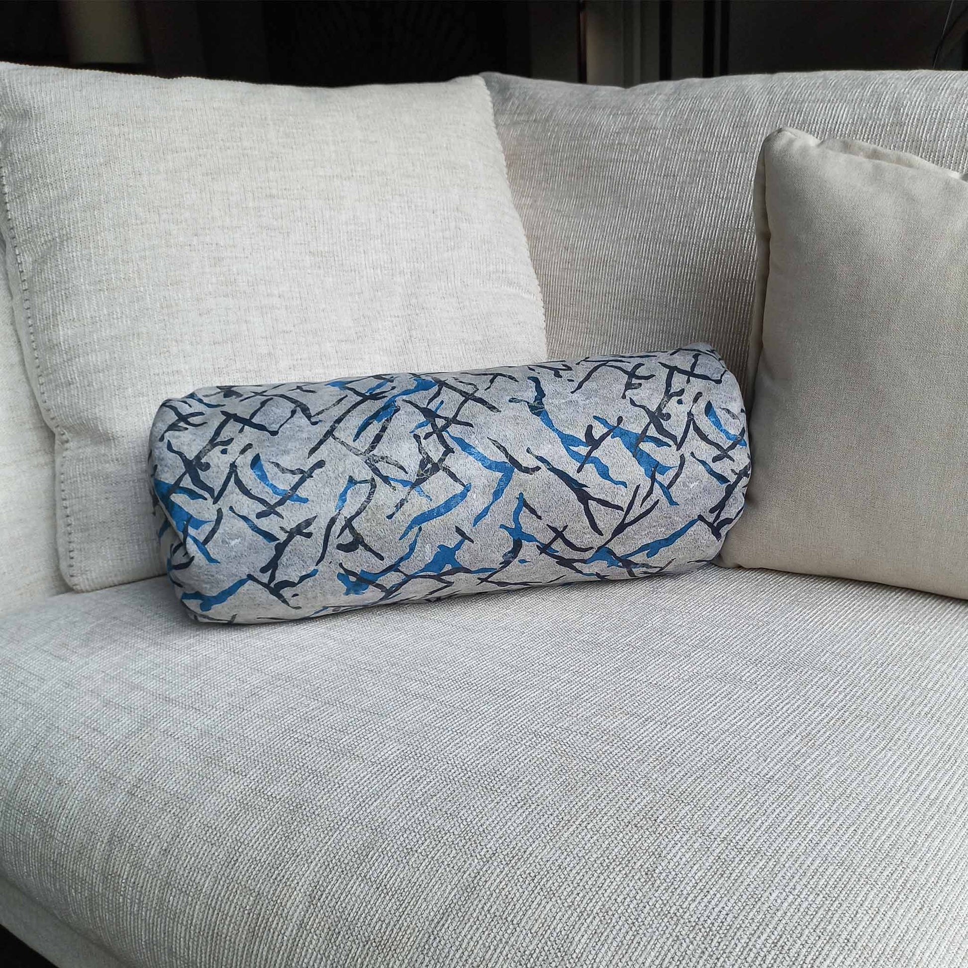 Printed decorative bolster cushion on sofa