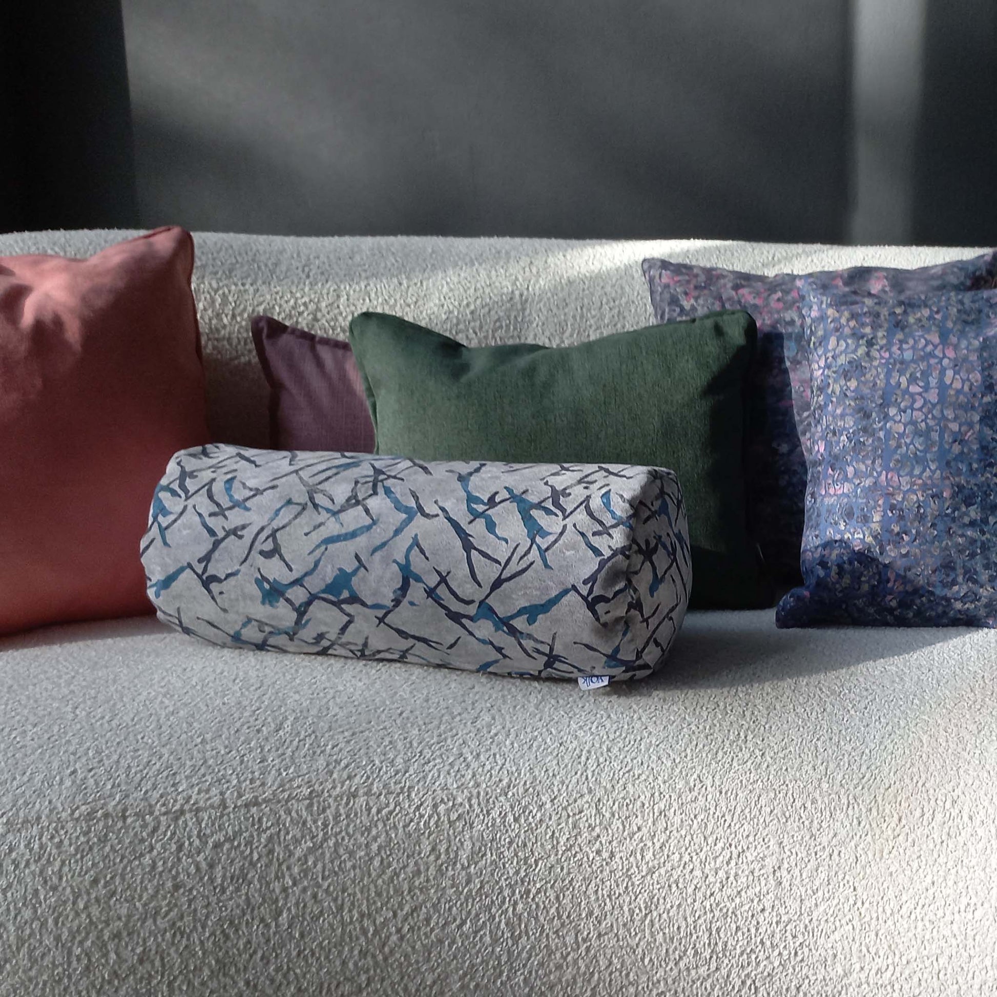 Printed and solid colour cushions on sofa