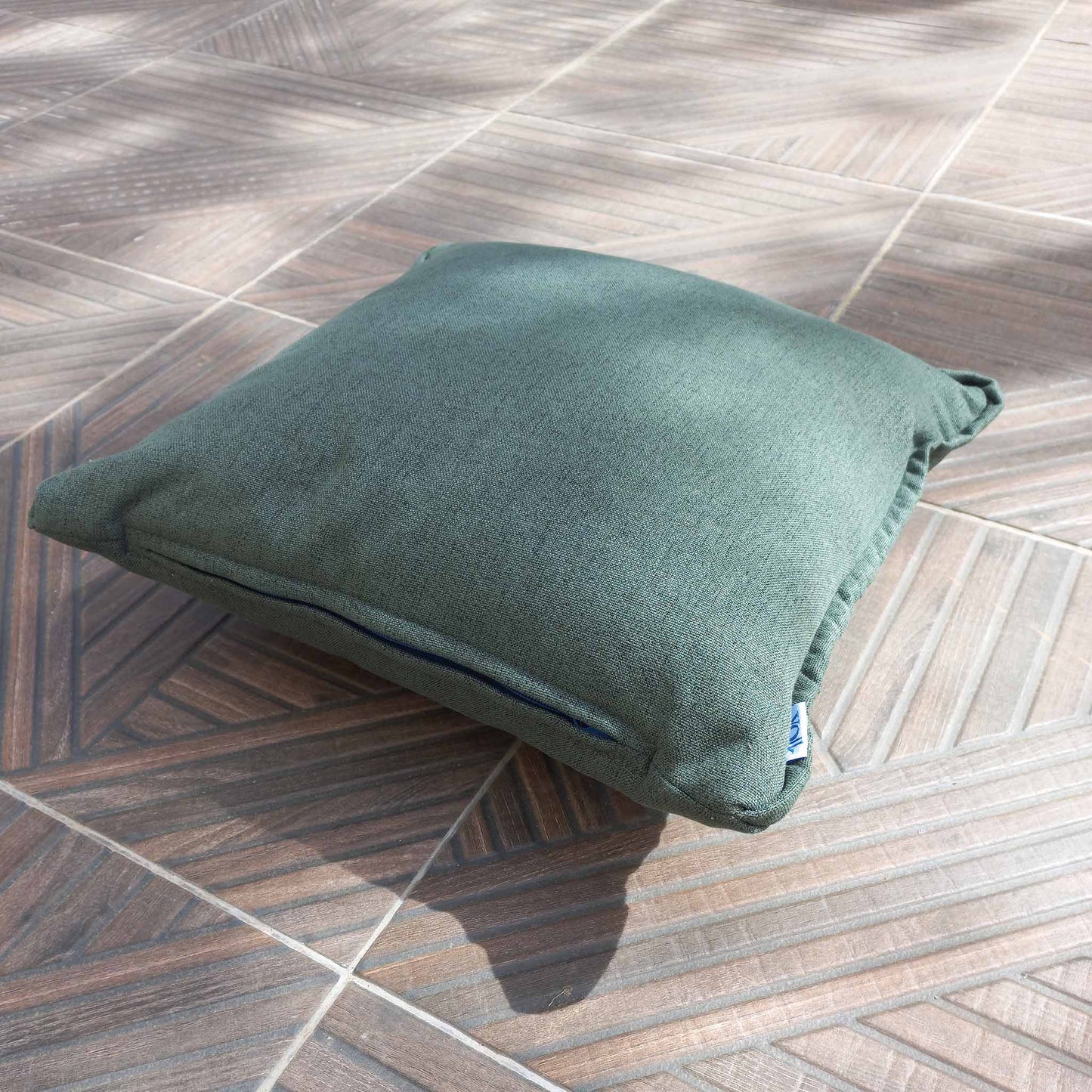 Green decorative cushion on a patio floor