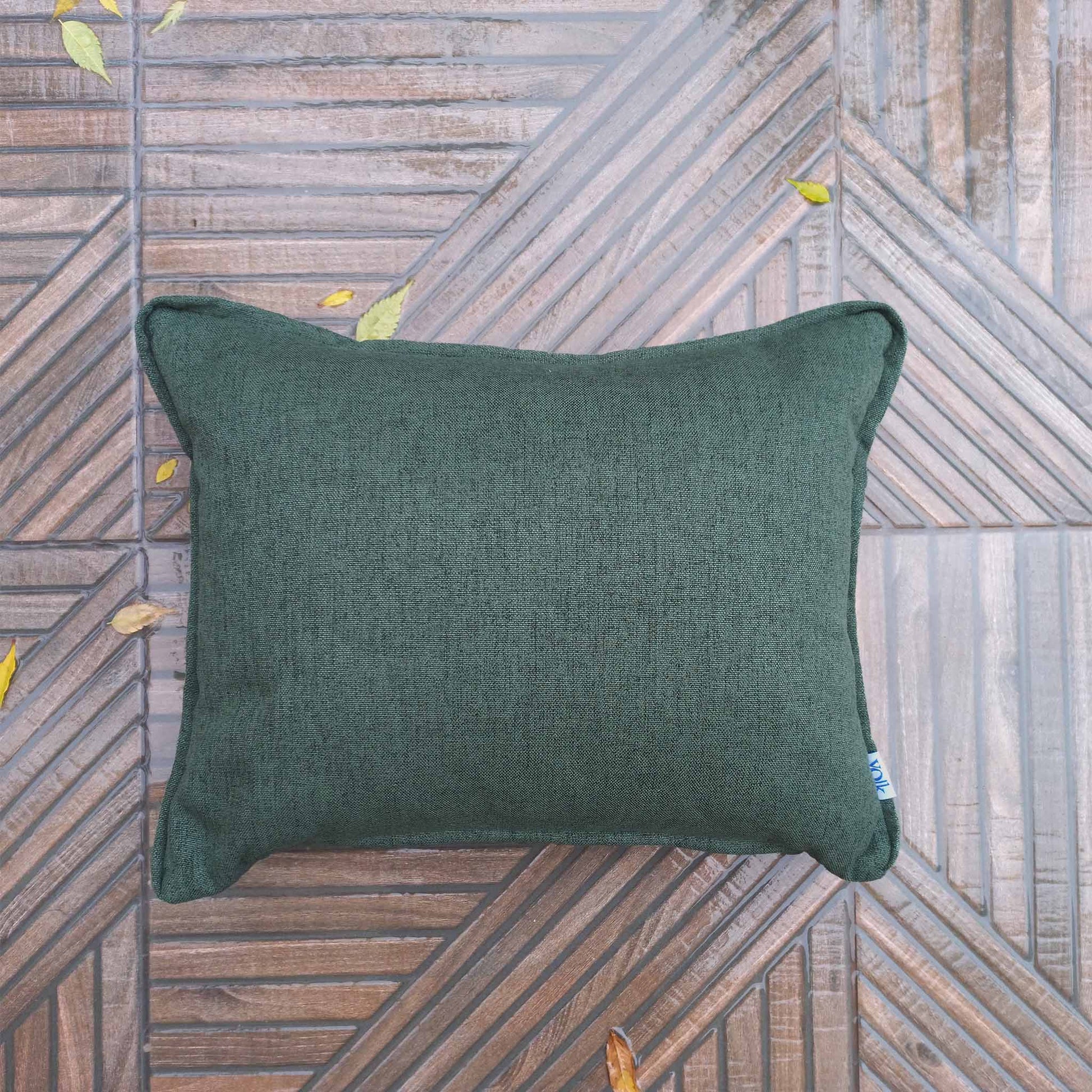 Dark green rectangular decorative cushion on a rainy balcony