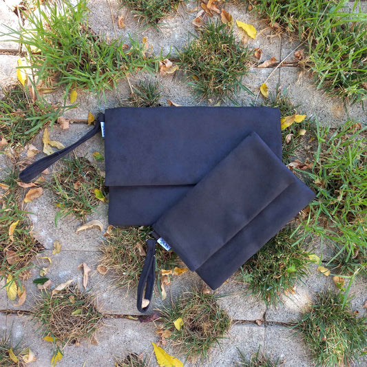 Two black clutches on a garden