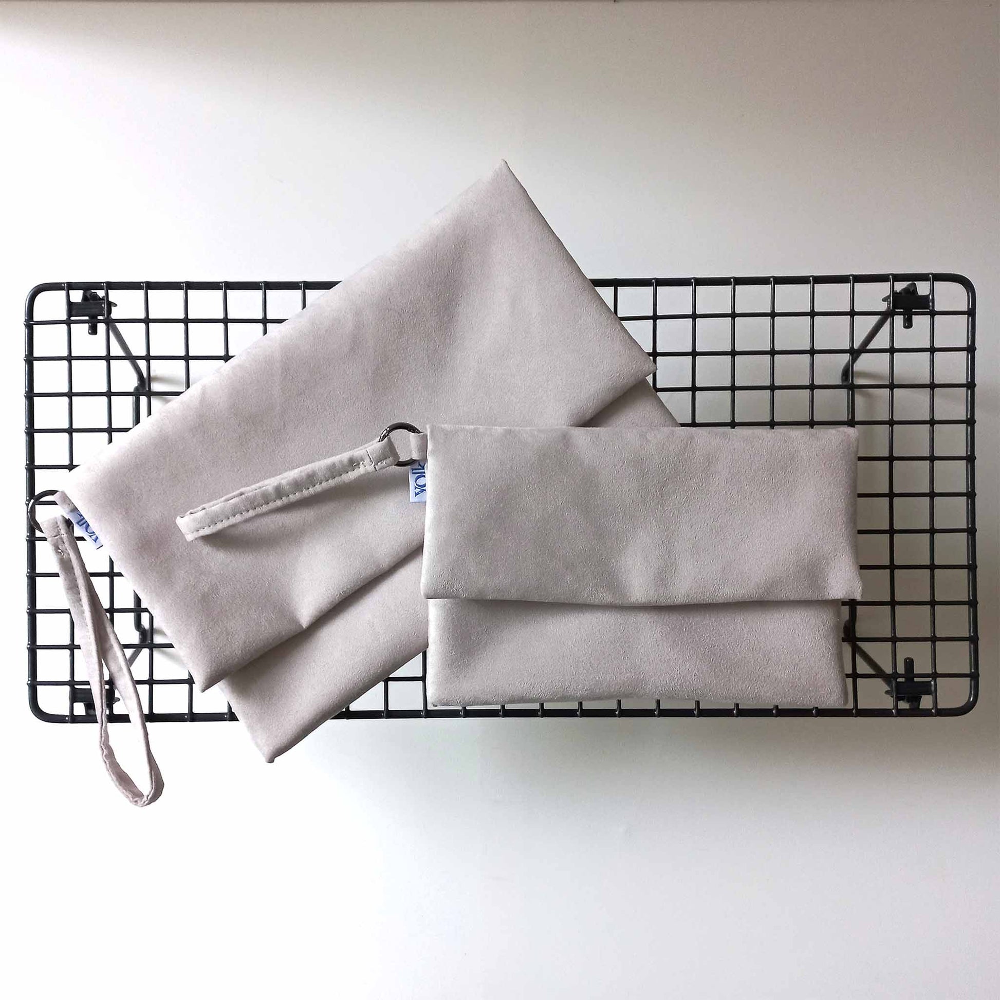 Two off white clutch bags with wrist strap