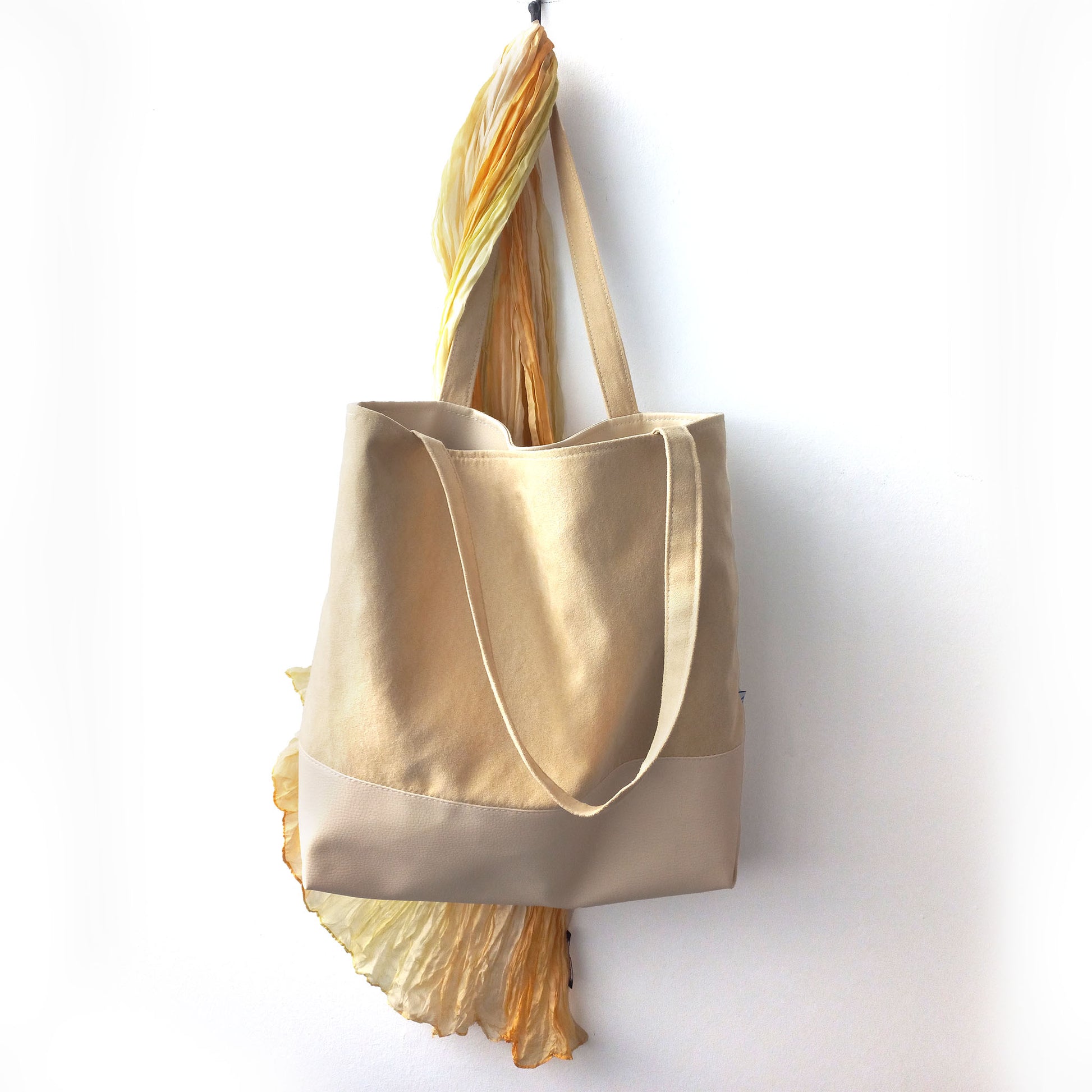 Sand yellow shoulder bag and a scarf on a hanger 