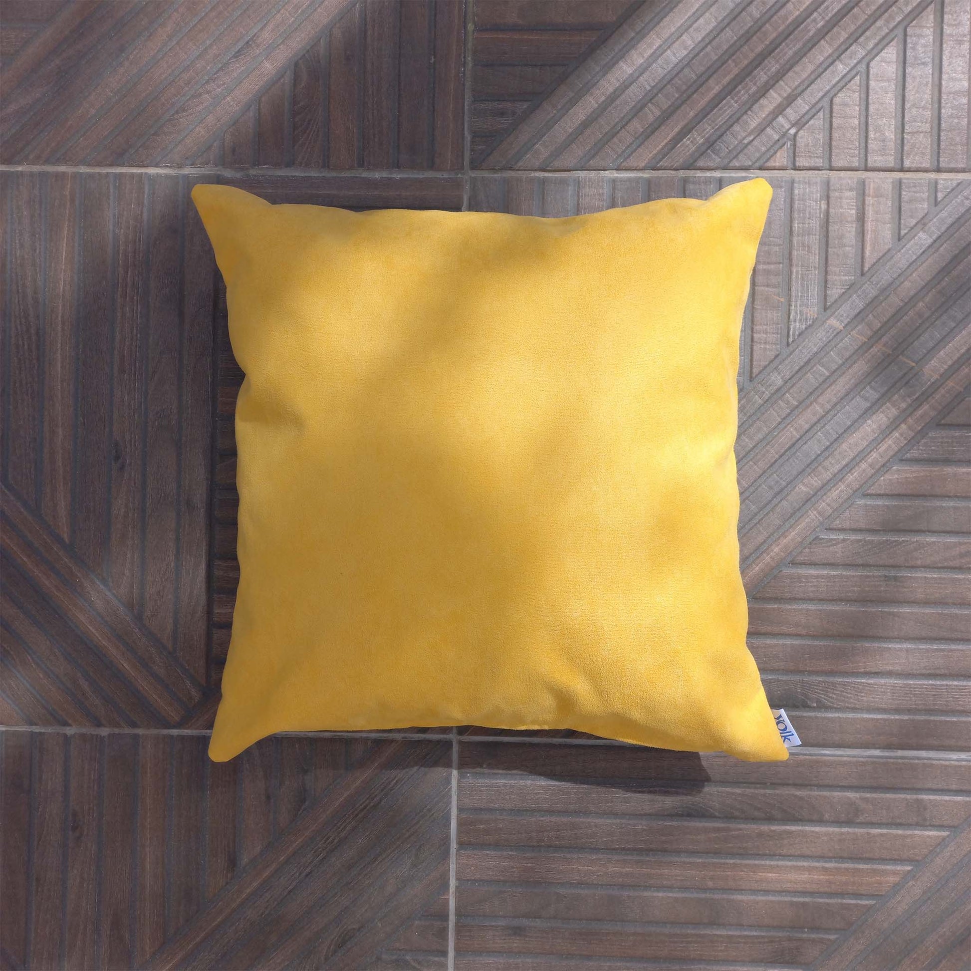 Yellow decorative cushion on a patio floor